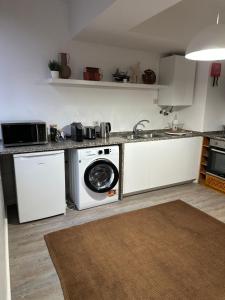 a kitchen with a washing machine and a sink at Costa da caparica in Costa da Caparica