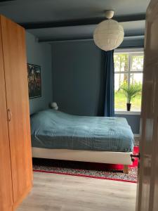 ein Schlafzimmer mit einem Bett und einem Fenster in der Unterkunft Stylish 2-Bedroom Apartment in a Cozy Neighborhood in Reykjavík