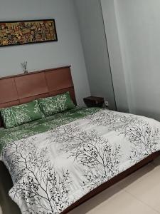 Un dormitorio con una cama con un edredón blanco y negro. en guest house 68, en Bandung