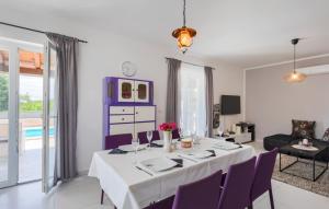 ein Esszimmer mit einem weißen Tisch und lila Stühlen in der Unterkunft Villa Melnica by Villas Guide in Barban