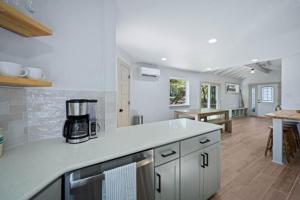 une cuisine avec des armoires blanches et un comptoir dans l'établissement NEW Campfire Cottage River Access Shared Pool, à Wimberley