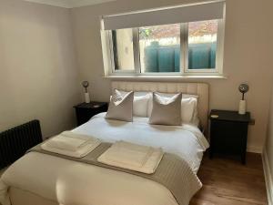 a bedroom with a white bed with two windows at Victoria Gate Lodge in Derry Londonderry