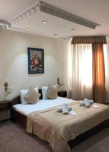 a bedroom with a large bed with two pillows at Nur M Hotel in Yakkasaray +4 photos