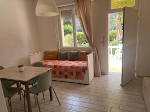 un soggiorno con un letto e un tavolo con sedie di Appartamento Il Garofano a Quercianella