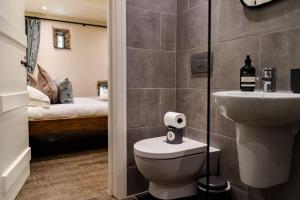 a bathroom with a toilet and a sink and a bed at Carrholme Cottage in Settle +36 photos