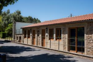 a building with a fence next to a road at Apartamento Pescadeira de Agar in Rego de Santa Marina