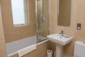 a bathroom with a shower and a sink and a tub at The Treyarnon Suite in St Merryn +9 photos