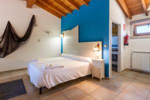 a bedroom with a white bed and a blue wall at Apartamento Pescadeira de Agar in Rego de Santa Marina