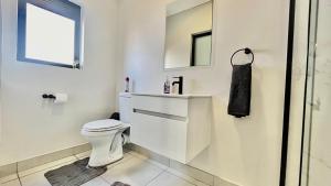 a white bathroom with a toilet and a window at 745@TheBlyde in Pretoria +13 photos