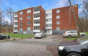 two cars parked in a parking lot in front of a building at BEGE APARTMENTS HushStay in Marl