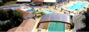 an overhead view of a resort with two pools at Charmant mobil home au Cap Ferret, idéalement situé dans un camping 4 étoiles Sibulu les Embruns à Claouey in Lège-Cap-Ferret
