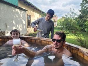 two men in a swimming pool with a glass of beer at Hirschwangerhof - Commons Hub in Reichenau