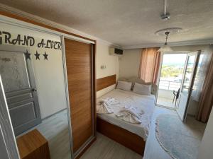 a small bedroom with a bed and a sliding glass door at Grand Alver Otel in Edremit +24 photos