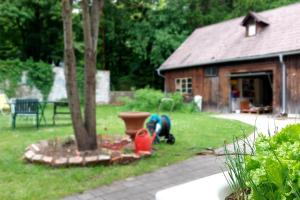 a man is working in a yard next to a tree at Hirschwangerhof - Commons Hub in Reichenau