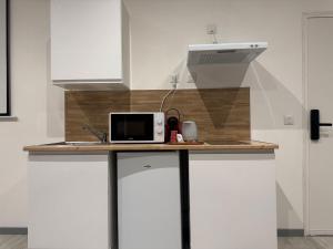a microwave on a counter in a kitchen at Bahana Bay in Tourcoing +14 photos