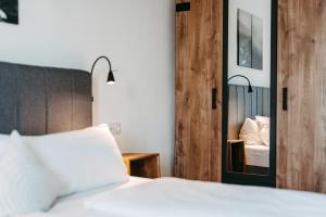 a bedroom with a bed and a mirror at Hotel Gasthof Kern in Halfing
