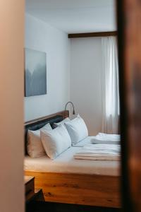 a bedroom with a bed with white pillows at Hotel Gasthof Kern in Halfing