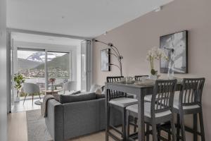 ein Wohnzimmer mit einem Tisch und einem Sofa in der Unterkunft Northstay - Tromsø Outlook, Amazing City & Mountain Views in Tromsø