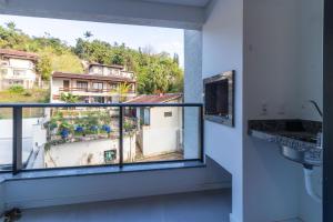 a bathroom with a large window with a view at Apto a 4min da Vila Germânica KW1383 in Blumenau