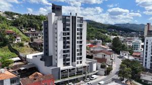 an overhead view of a white building in a city at Apto a 4min da Vila Germânica KW1383 in Blumenau