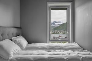 ein Schlafzimmer mit einem Bett und einem Fenster mit einem Berg in der Unterkunft Northstay - Tromsø Outlook, Amazing City & Mountain Views in Tromsø