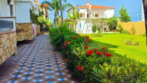 a garden path with red flowers and a house at L'unico - Sea View, Pool & Jaccuzi in Oued Laou