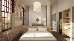 a bedroom with a bed and a brick wall at Pocketbook Hotel and Baths in Hudson
