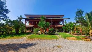 a house with a gravel driveway in front of it at ฮักจังโฮมสเตย์ ที่พักแม่แตง in Chiang Mai