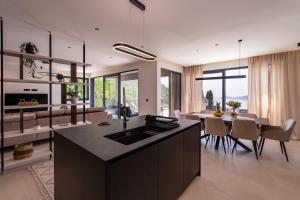 a kitchen and living room with a table and chairs at Green Sunrise Villa in Brsečine +33 photos