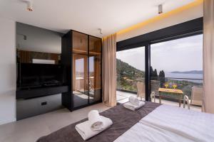 a bedroom with a large bed with a large window at Green Sunrise Villa in Brsečine