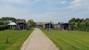 a walkway leading to a large yard with houses at Recreatie aan de Vecht, Hooibergje 2, Weesp in Weesp
