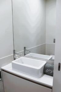 a bathroom with a white sink and a mirror at Beachside 2 BD Apartment | Balcony | AC in Vila Nova de Gaia +22 photos