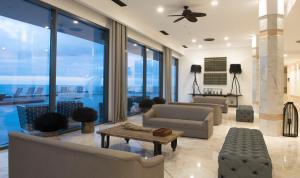 a living room with couches and a ceiling fan at Hotel Baia Azul in Funchal