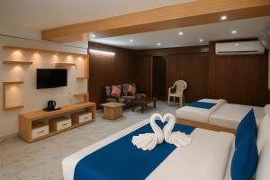 AyodhyaHotel Rajnandani Palace by IQ Hotels - Steps from Ram Mandir, Ayodhya的一间有两张床和一台电视的酒店房间