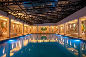a swimming pool in a building with paintings on the walls at Kuriftu Resort & Spa African Village in Gefersa
