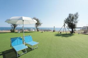 two blue chairs and an umbrella and a swing at Cala Batteria - Camping & Village in Bisceglie
