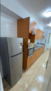 a kitchen with a stainless steel refrigerator and wooden cabinets at Experencia Tarragona-2hab-2bañós in Calama +7 photos