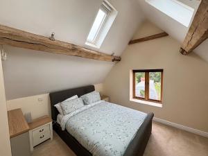 a bedroom with a bed and two windows at Woodland Forge by Oracle in Over Whitacre
