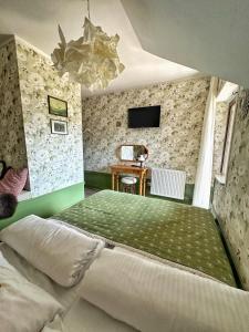 a bedroom with a green bed and a table at Willa Wydra in Krościenko