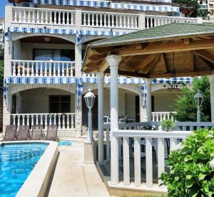 a large house with a swimming pool and a deck at Guest House Vila Eli in Herceg-Novi