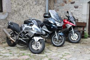 two motorcycles parked next to a stone wall at Hotel Moto-Rural "VEGALION" in Las Salas