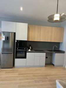 eine Küche mit weißen Schränken und einem Edelstahlkühlschrank in der Unterkunft Sea Breeze Polo Residences - One bedroom apartment in Nardaran + 6 Fotos