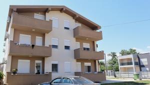 a building with a car parked in front of it at Elit Apartmani in Ulcinj +19 photos