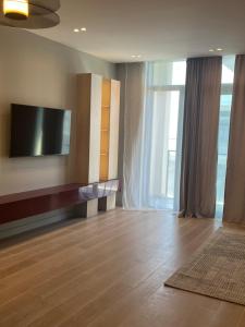 ein Wohnzimmer mit einem Flachbildfernseher an der Wand in der Unterkunft Sea Breeze Polo Residences - One bedroom apartment in Nardaran