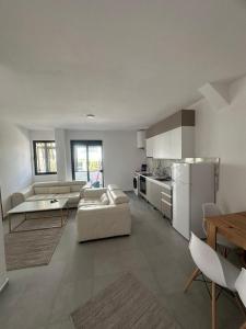 a large living room with a couch and a kitchen at Seaside 2-br flat with terrace in Golem