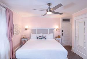 een slaapkamer met een wit bed en een plafondventilator bij Inn on Charlotte Boutique Hotel in St. Augustine
