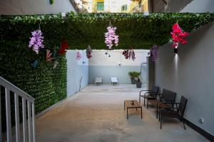 una stanza con una parete ricoperta di edera con sedie e fiori di Spend Night a Napoli