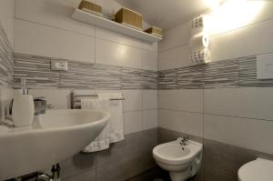 La salle de bains blanche est pourvue d'un lavabo et de toilettes. dans l'établissement La Casetta di Mary, à Termoli
