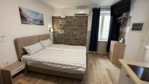 a bedroom with a bed and a brick wall at Morski Val in Piran