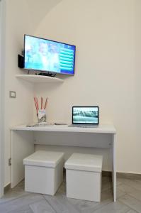 - un bureau avec un ordinateur portable et un moniteur sur un mur dans l'établissement La Casetta di Mary, à Termoli
